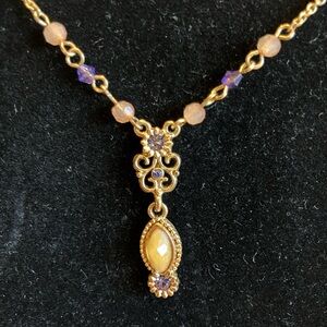 1928 BRAND WITH A CABOCHON GOLDEN STONE AND LAVENDER CRYSTALS
